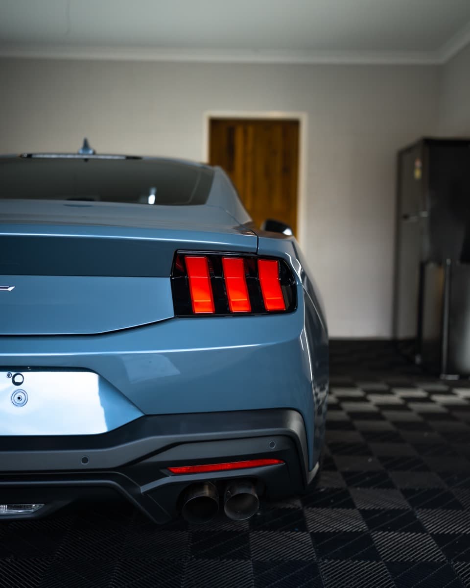Rear three-quarter of the Mustang showing the tail lights and coated paint