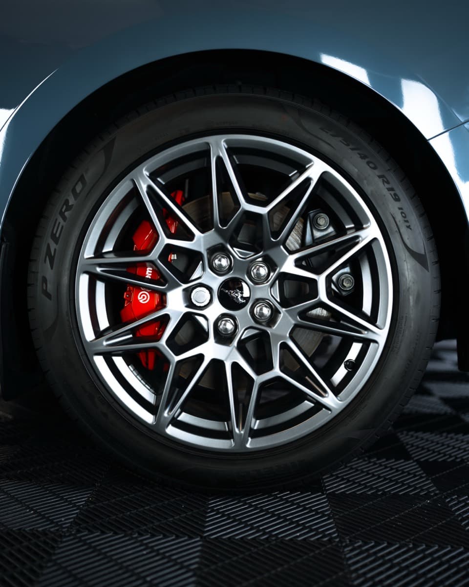 After: clean alloy wheel with red brake caliper